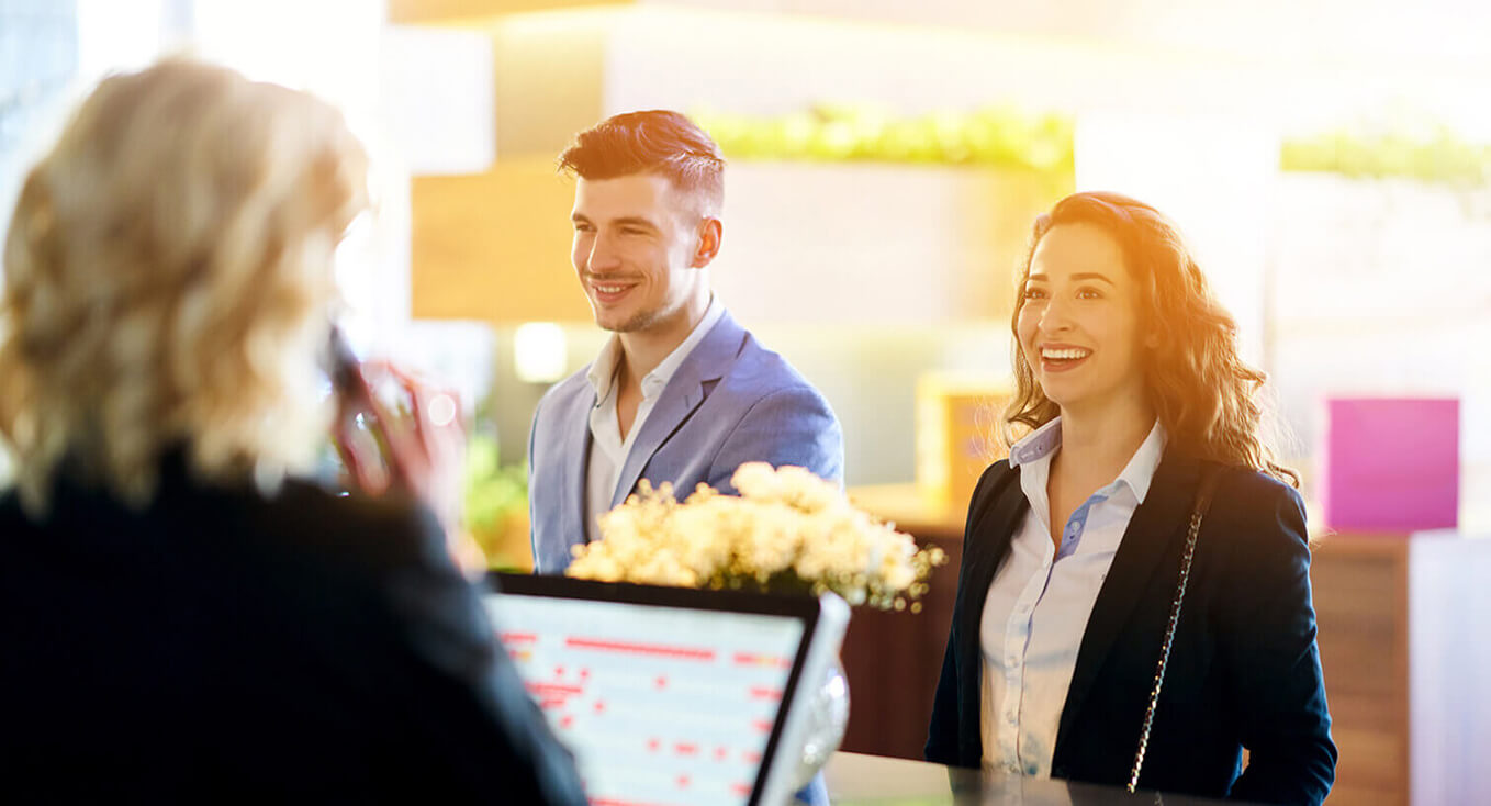 Guests being welcomed at a hotel front desk